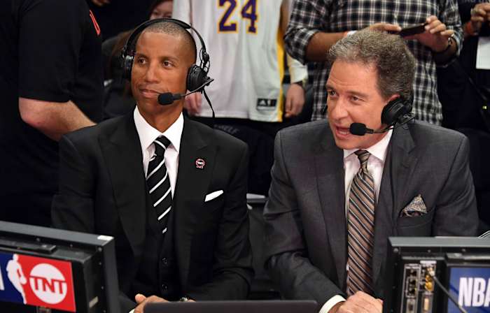 Reggie Miller and Kevin Harlan sit side by side in suits with headsets on